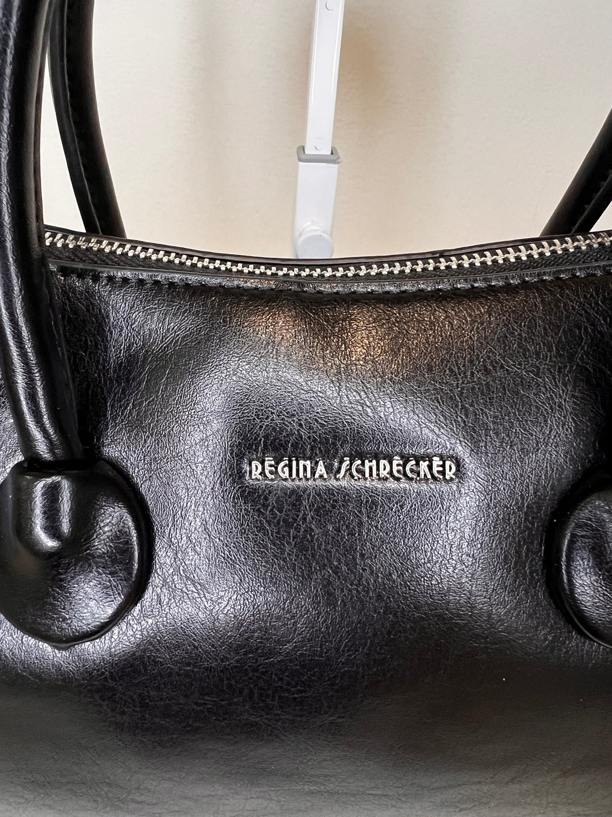Bauletto Regina Schrecker con tracolla, dettaglio del logo